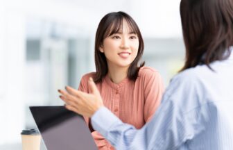 PCを見ながら話す2人の女性