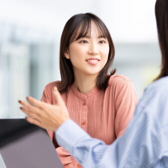 PCを見ながら話す2人の女性